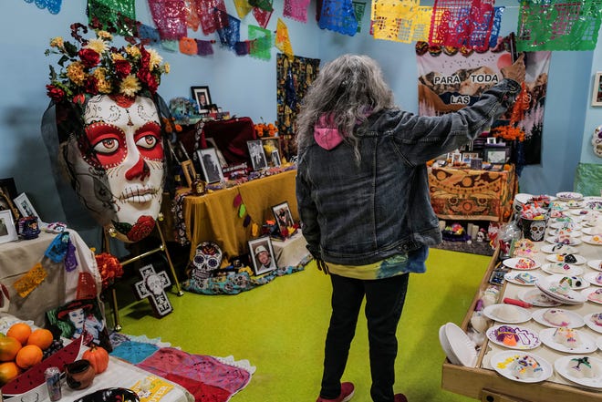 A woman takes a selfie at the Dia de los Muertos at the State of Michigan Library, and sponsored by Casa de Rosado Galeria and Cultural Center Friday, Nov. 1, 2024.