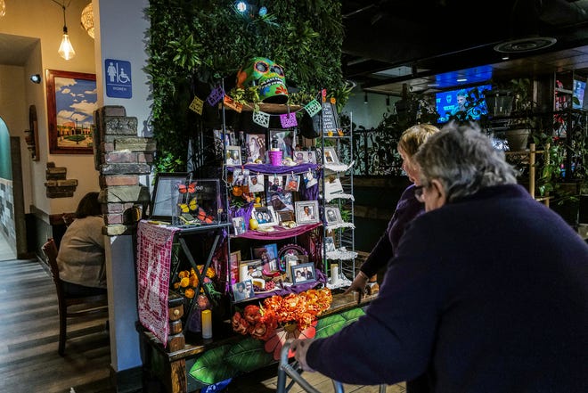 Judy Day, front, and Billie Jo Milner from Lansing look at the Dia de los Muertos ofrenda on display at Acapulco Mexican Cuisine restaurant in Frandor Friday, Nov. 1, 2024.