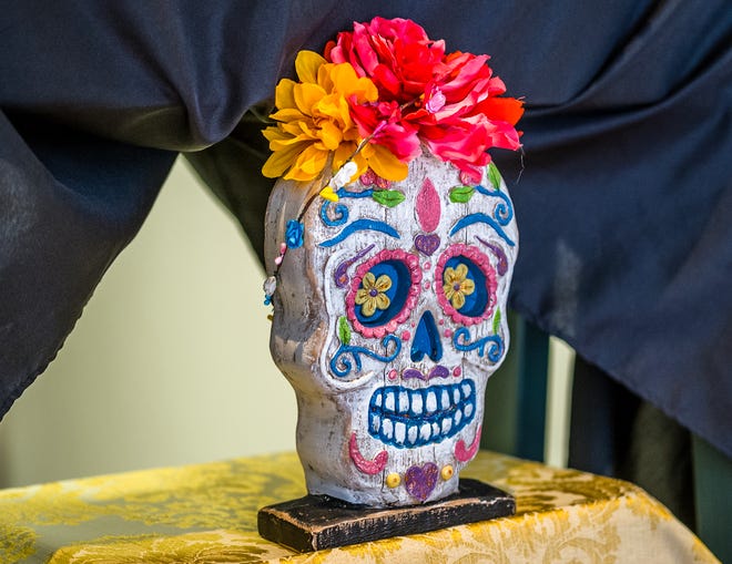 An old, battered, wooden calavera or skull is on an ofrenda or altar on display at Lansing City Hall Friday, Nov. 1, 2024. The ofrenda has been on display since Monday and celebrates Dia de los Muertos or Day of the Dead which is prevalent in Mexico and a few other countries. It coincides with the Catholic All Saints day November 1st that also includes children that have died, and All Souls Day on November 2nd for all who have passed. The celebration is a remembrance tradition that merges the Catholic and Aztec practices.