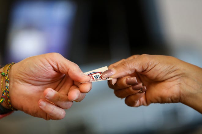 A poll worker hands a voter a sticker after submitting their ballot during early voting at the Franklin County Board of Elections in Columbus, Ohio Nov. 1.