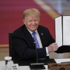 Then-President Donald Trump signs an executive order related to reforming the hiring process for federal jobs on June 26, 2020.