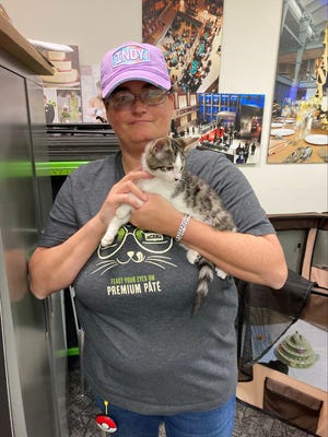 Animal Outreach of Shelby County board member Sarah Bair poses with 6-week-old Travis, one of eight kittens at the Indiana State Museum's TAY/gate kitten corner on Nov. 1, 2024. "He just wants to be held," Bair said.