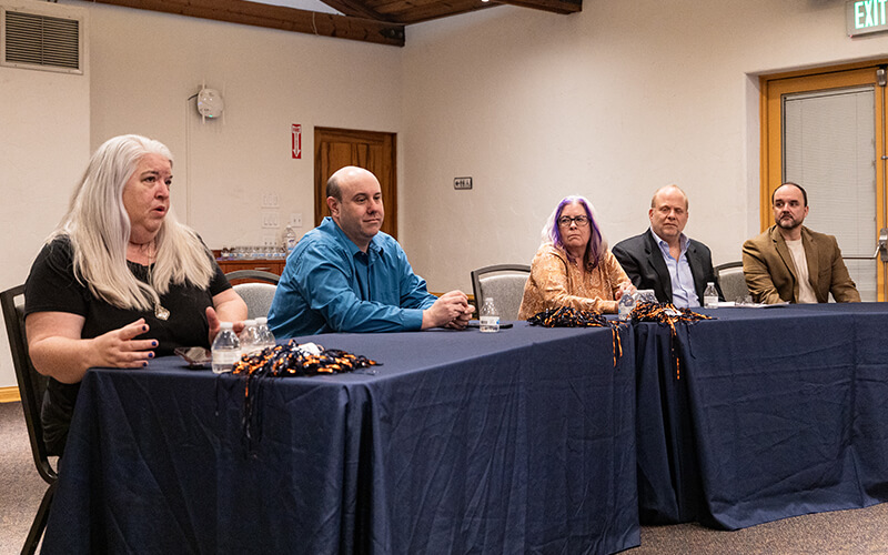 Four faculty members sitting at a table for a panel discussion