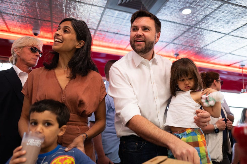 usha vance and jd vance smile while inside a crowded diner, two of their young children are with them